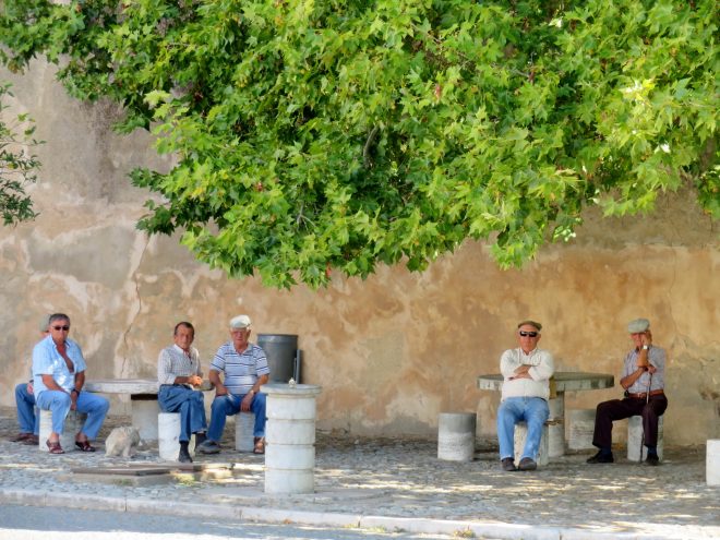 Five men sitting and watching in a Portuguese village